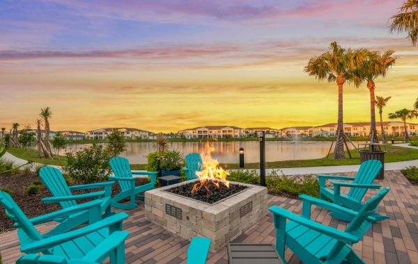 Large fire pit with seating next to a lake