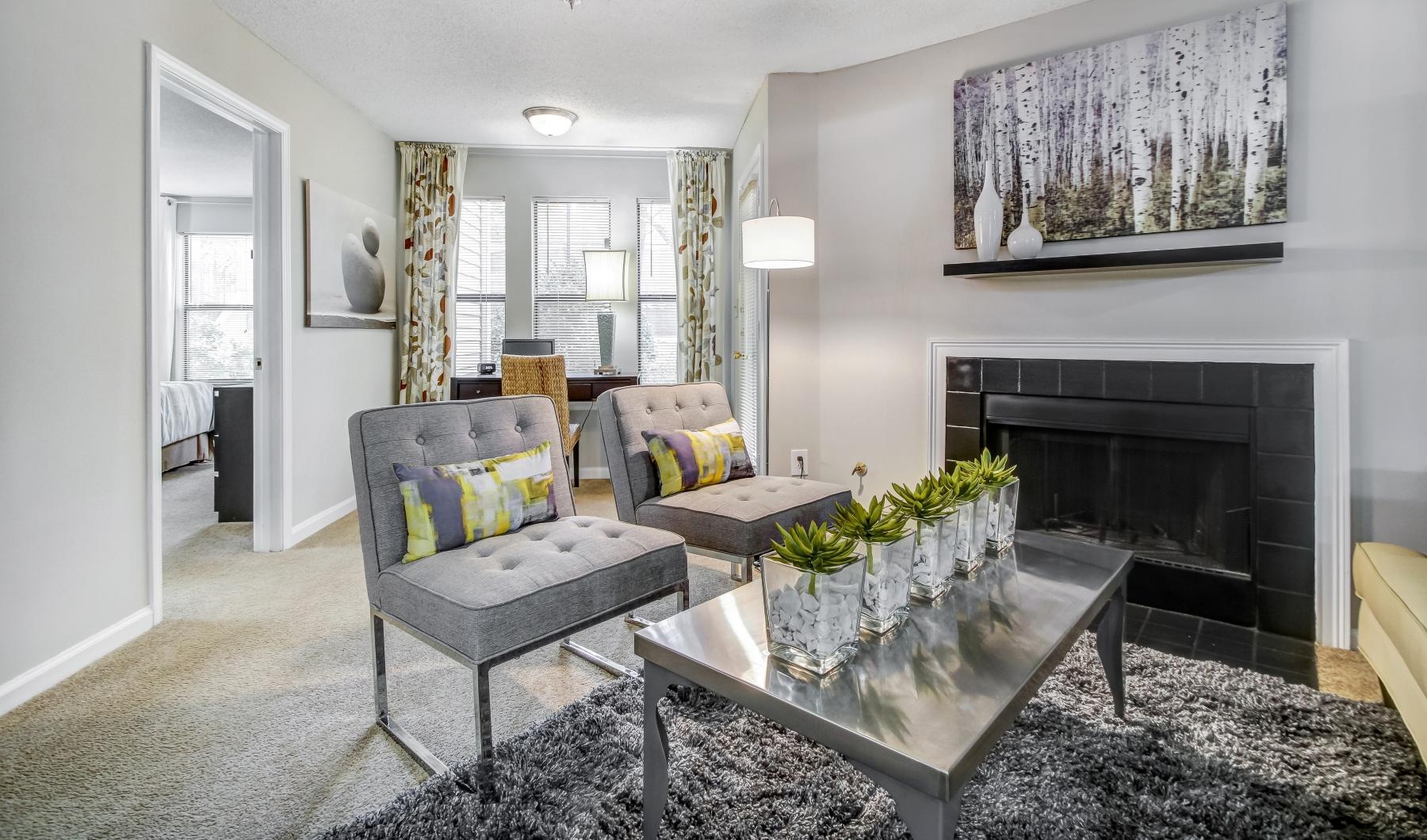 a living room with a fireplace and chairs