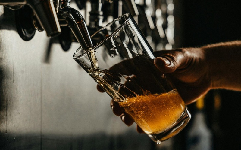 someone pouring a glass of beer
