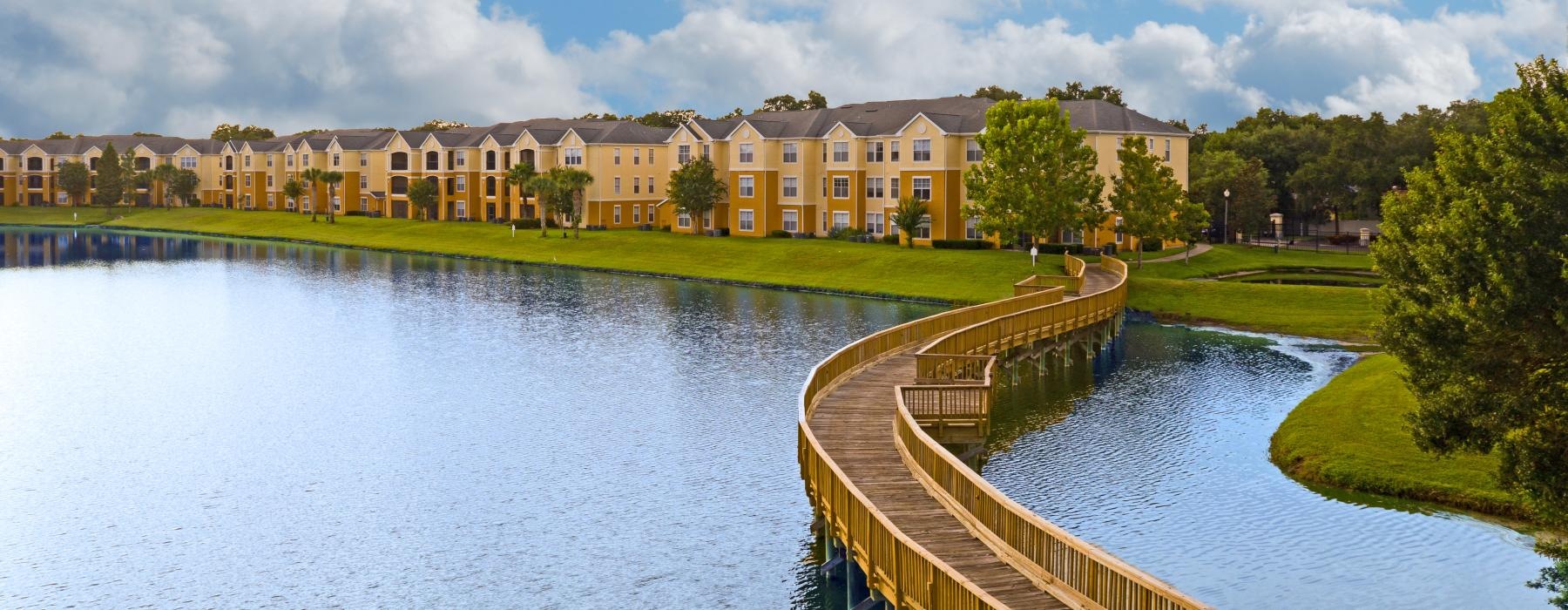 a wooden walking bridge over a pond