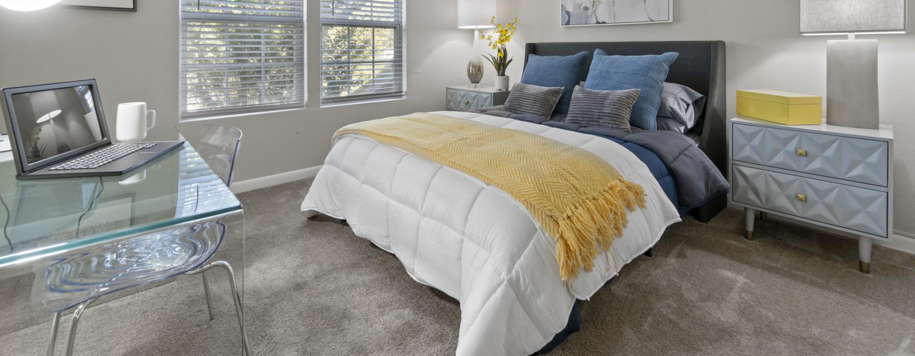 a bedroom with a bed and a side table and window