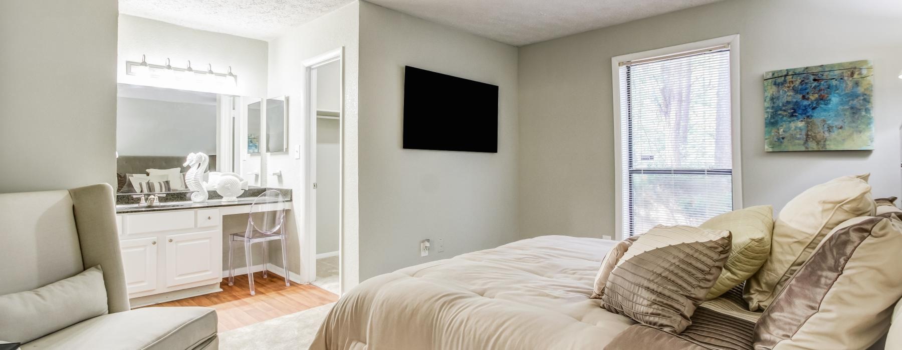 a large bedroom with a tv and a chair