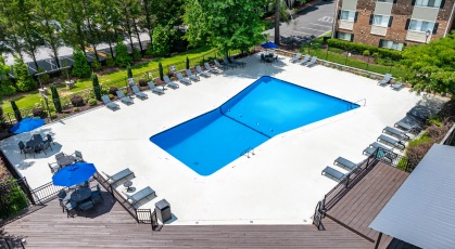 Sparkling swimming pool surrounded by lounge cha