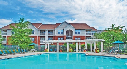 Sparkling blue pool with shaded areas and lounge chairs