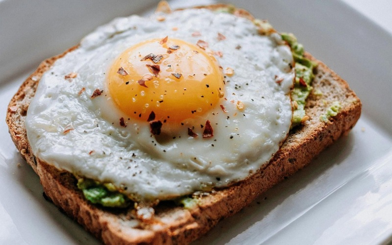 a breakfast sandwich with an egg on top