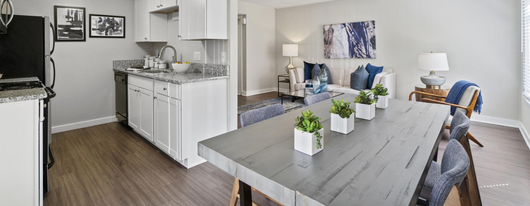 a dining room connected to a kitchen with a table and chairs