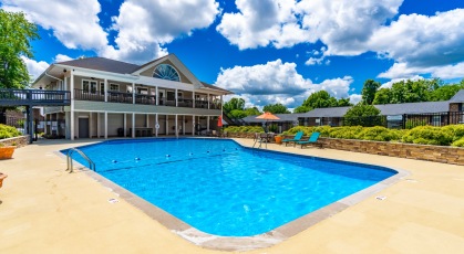 Large swimming pool with lounge seating and umbrellas 