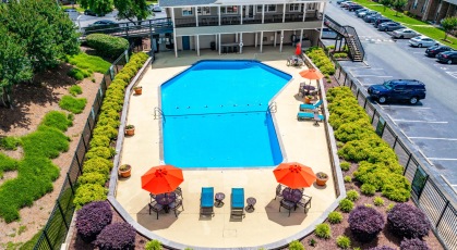 Large swimming pool with lounge seating and umbrellas 