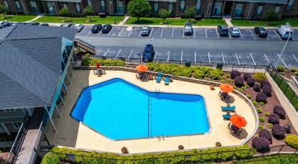 Large swimming pool with lounge seating and umbrellas 