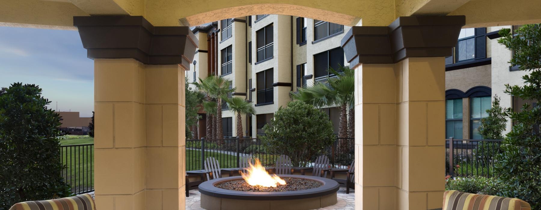 a large covered patio with seating and a firepit