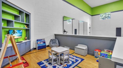 Fitness center playroom with TV and toys 