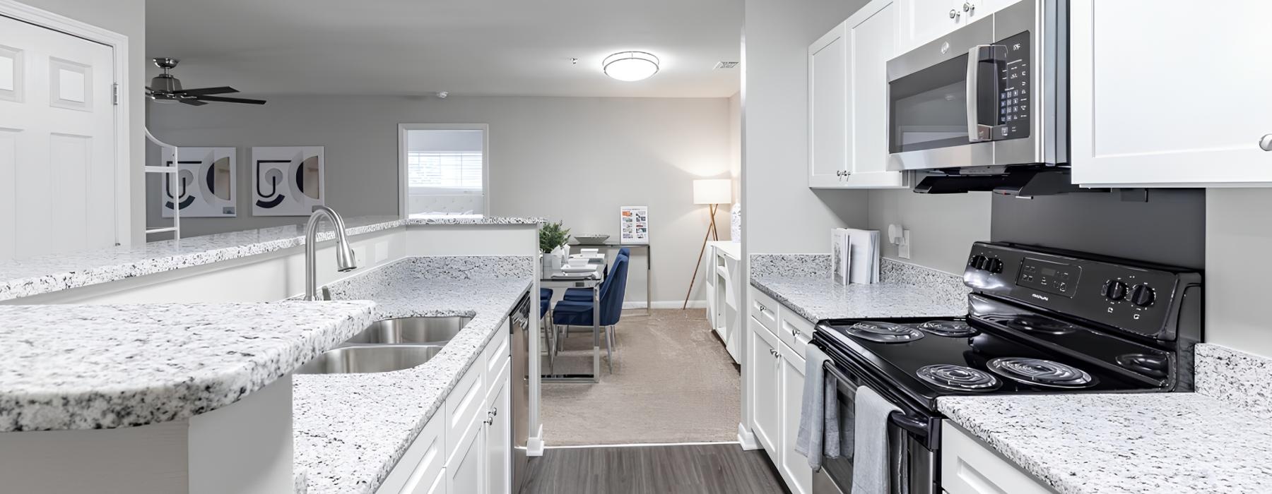 a kitchen with white cabinets and granite countertops