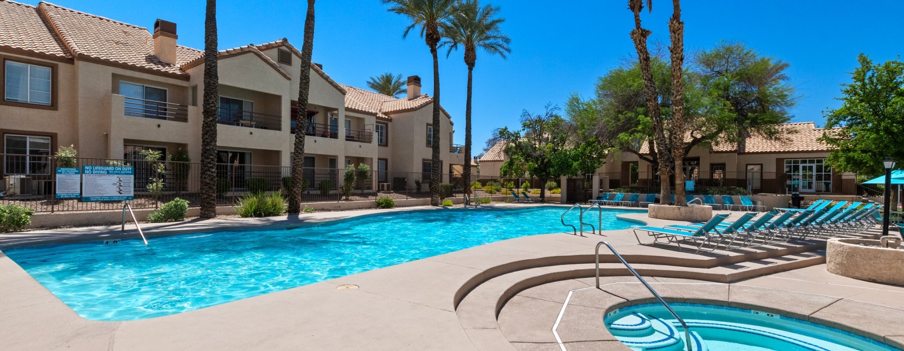 Swimming pool with lounge seating and umbrellas