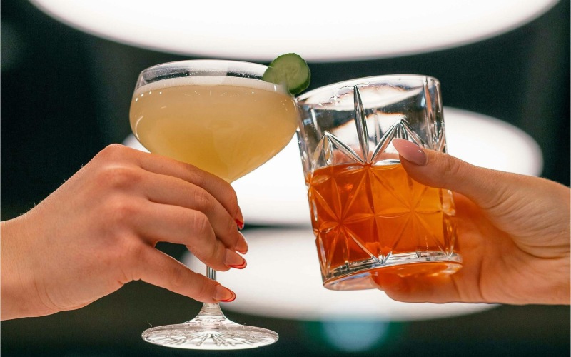 hands holding glasses with cocktails