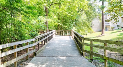 Wooden bridge through Raleigh's Crabtree Creek Greenway for walking and biking adjacent to Bryn Athyn at Six Forks