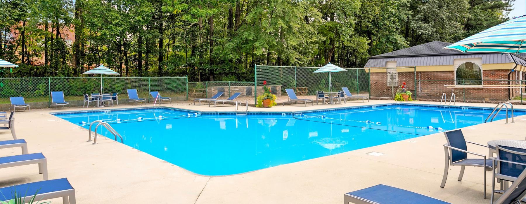 a swimming pool with a fence and trees in the background