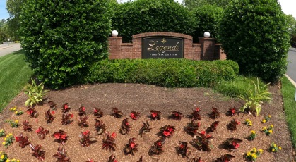Brick sign with gold lettering above flower bed welcoming you to Legends at Virginia Center