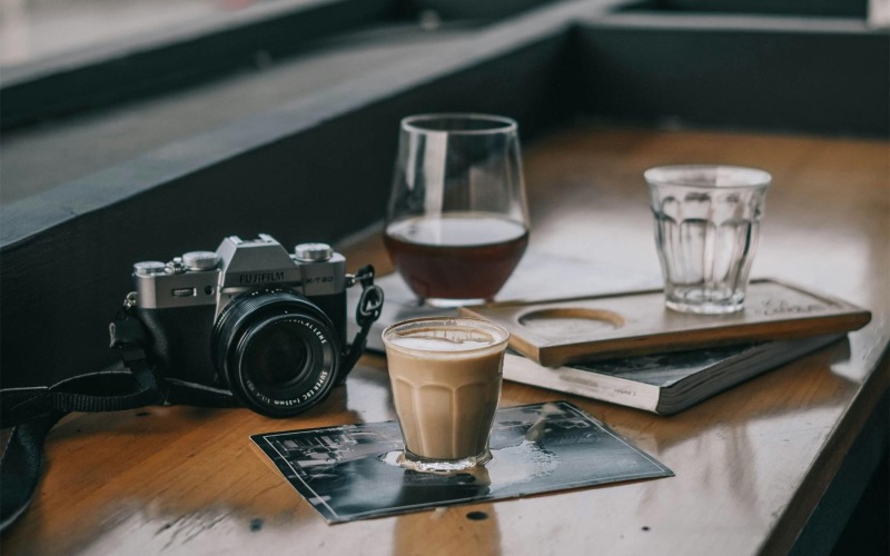 a camera and cup of coffee on a table