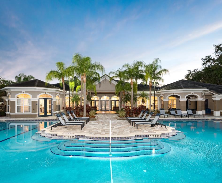 a swimming pool with clubhouse in the background