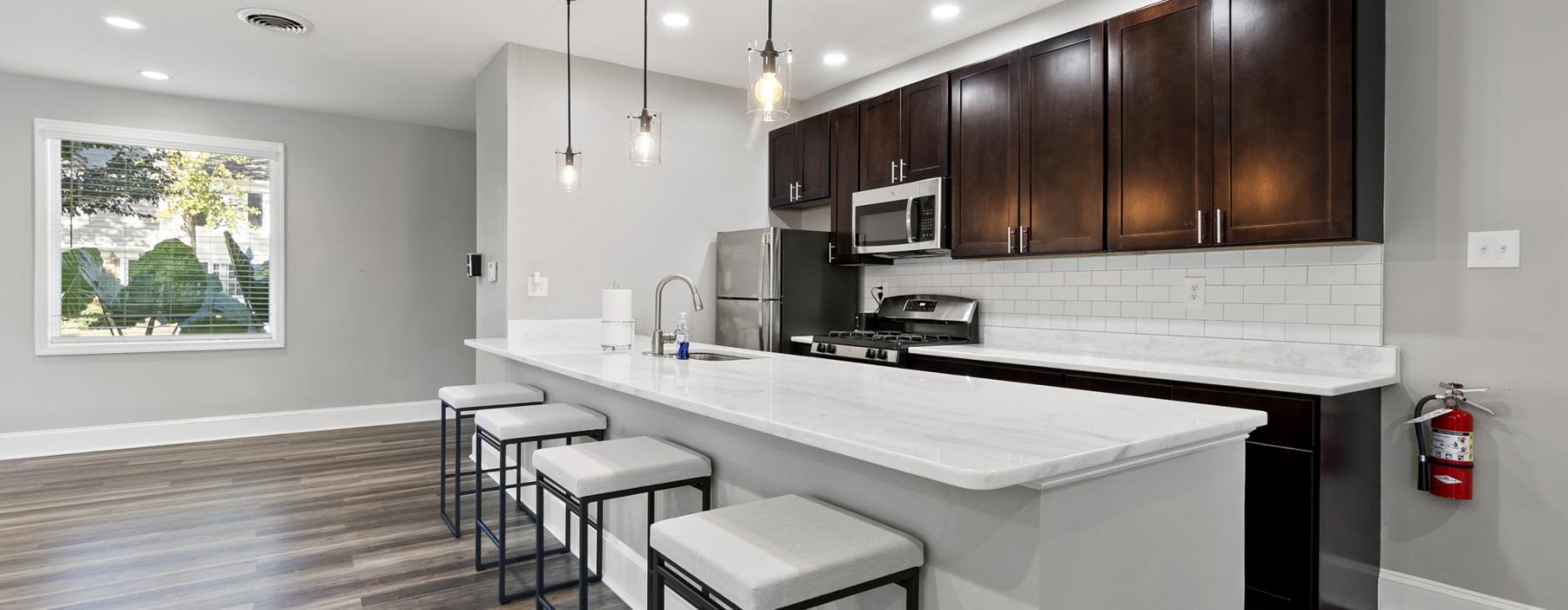 a kitchen with a bar stool and a white counter top