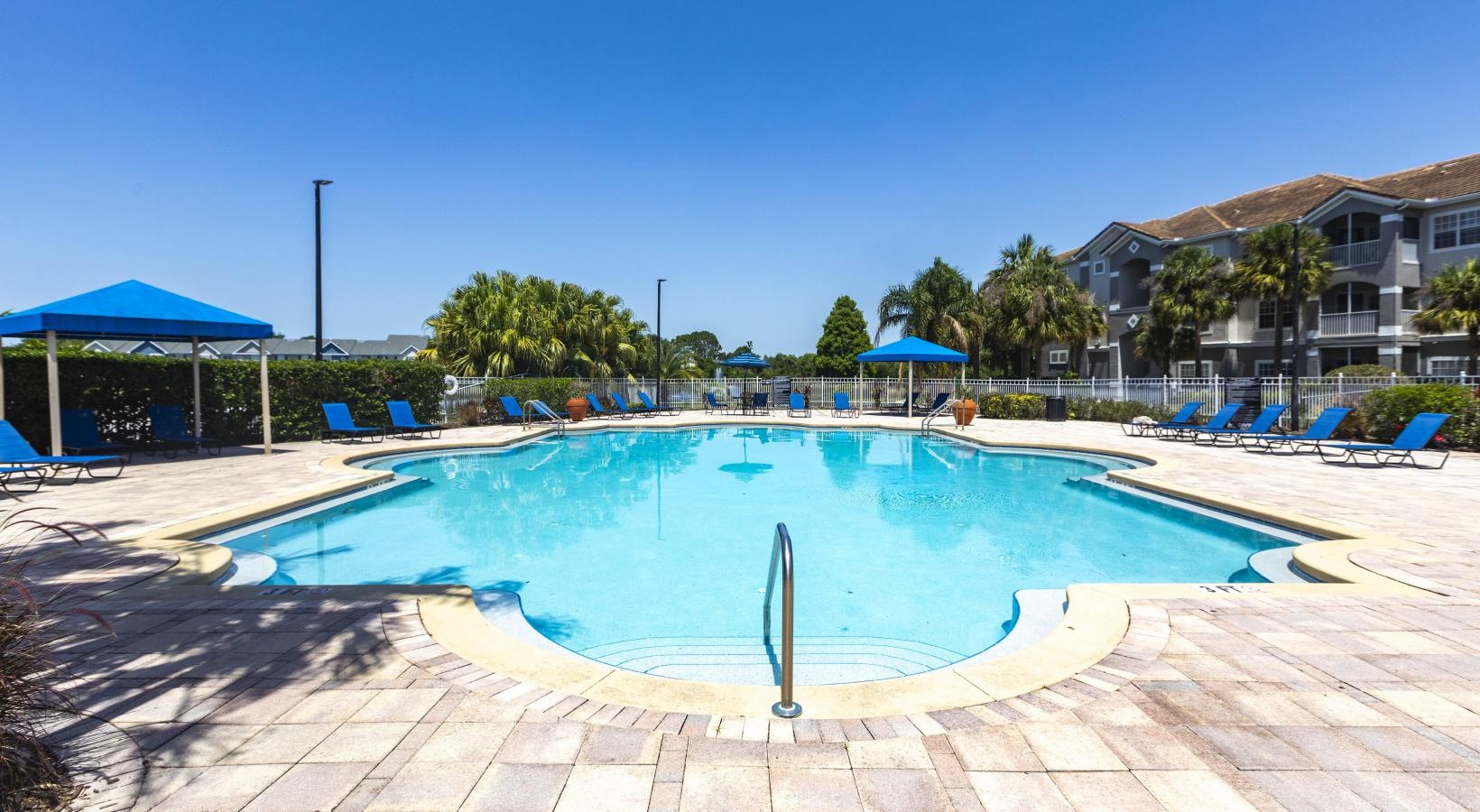 Swimming pool with lounge seating and umbrellas