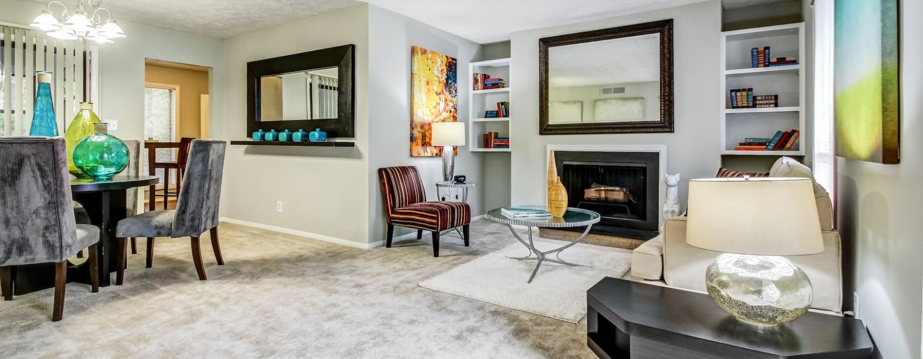 a living room with a fireplace, tables and chairs