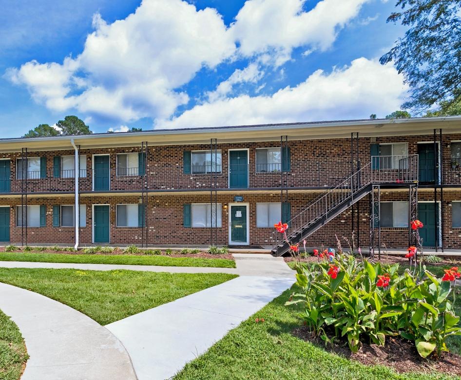 a building with a walkway and grass