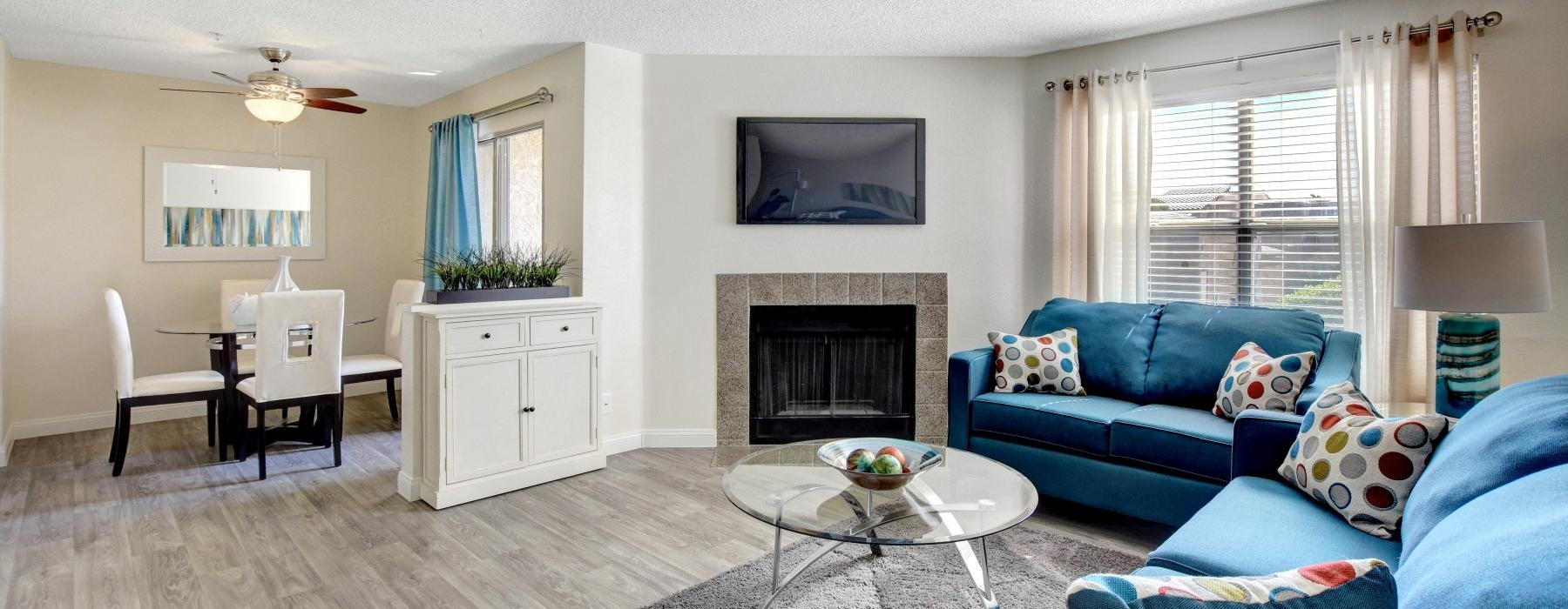 a living room with blue couches tv and fire place