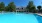 Beautiful blue swimming pool with pergola and furniture around
