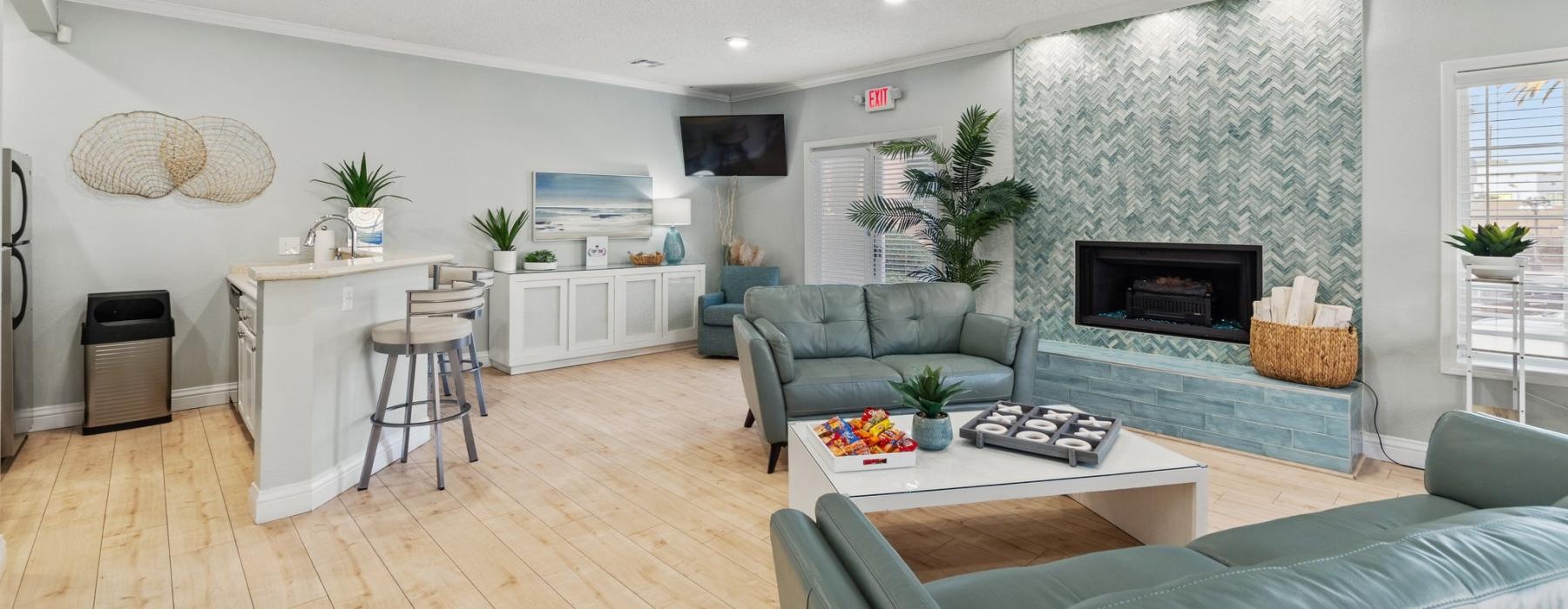 a clubroom with a fireplace, couches and a tv