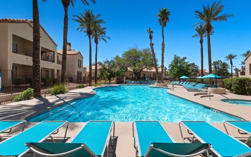 a pool with lounge chairs around it
