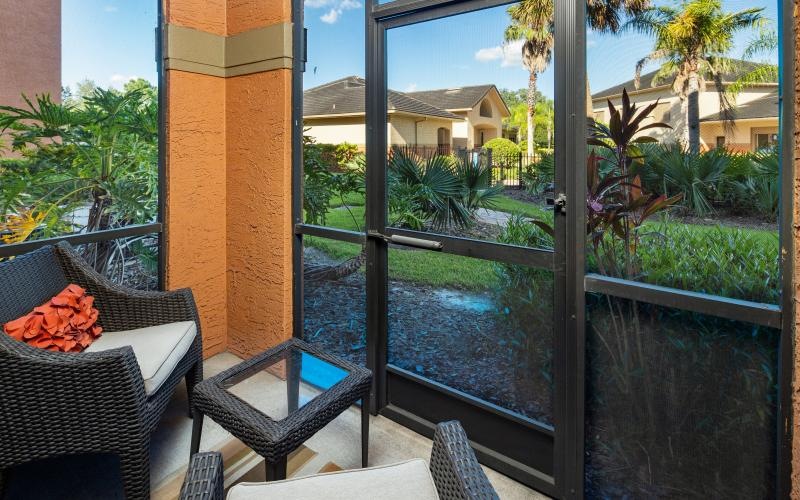 a room with a glass door and a patio with chairs and a table