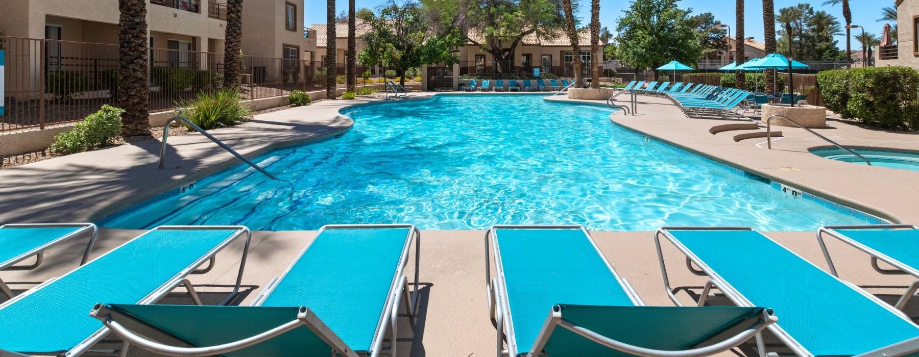a pool with lounge chairs around it