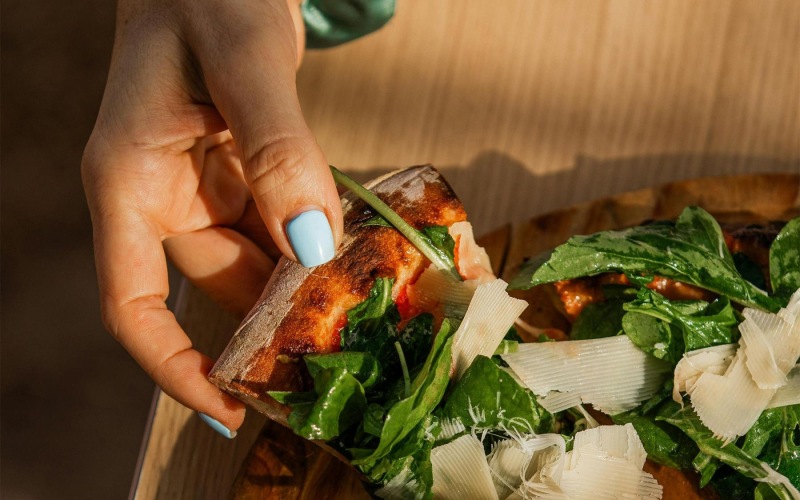 a person holding a slice of pizza