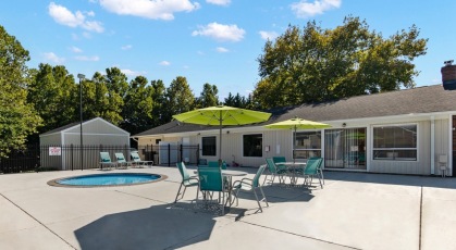 Spa with pool deck seating and umbrellas 