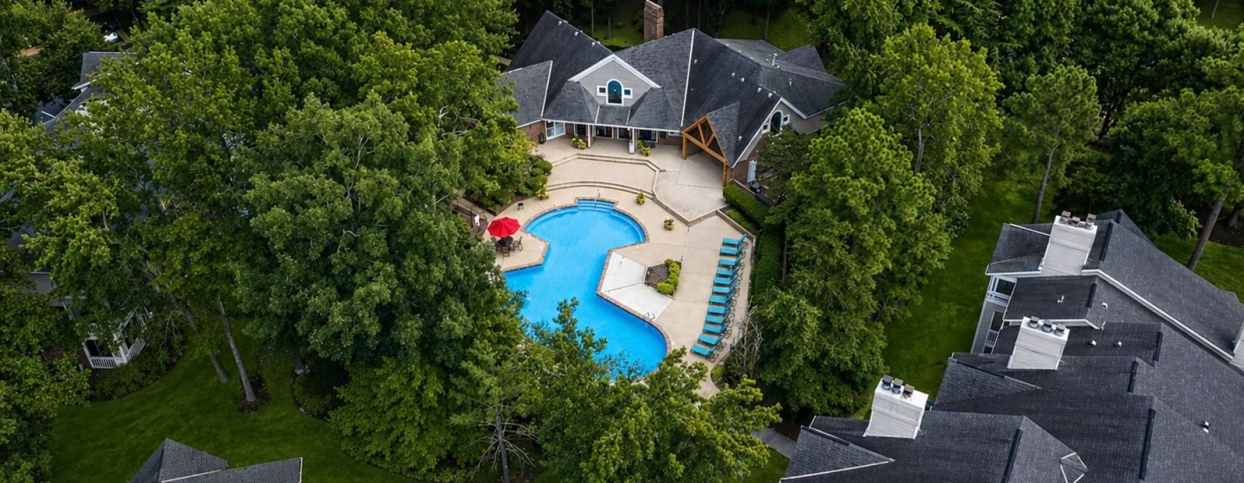 a swimming pool with chairs and umbrellas next to it