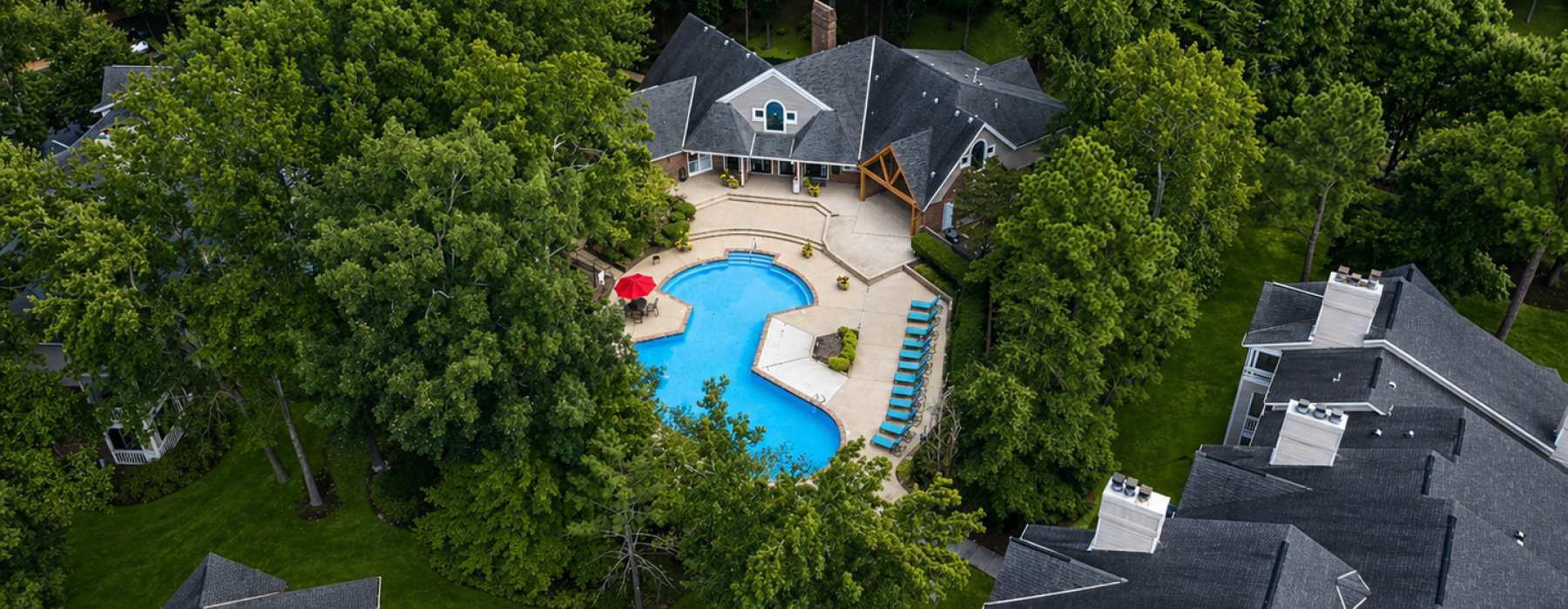 a swimming pool with chairs and umbrellas next to it
