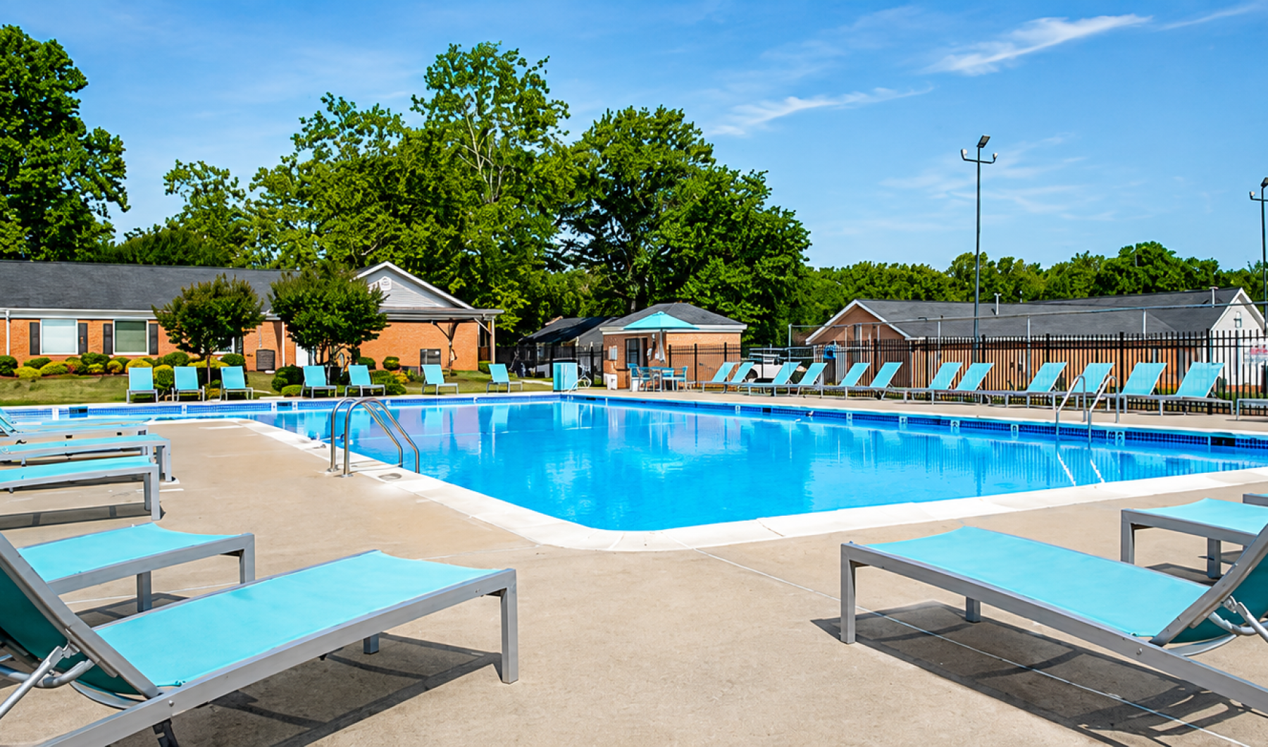 a pool with lounge chairs and umbrellas by it