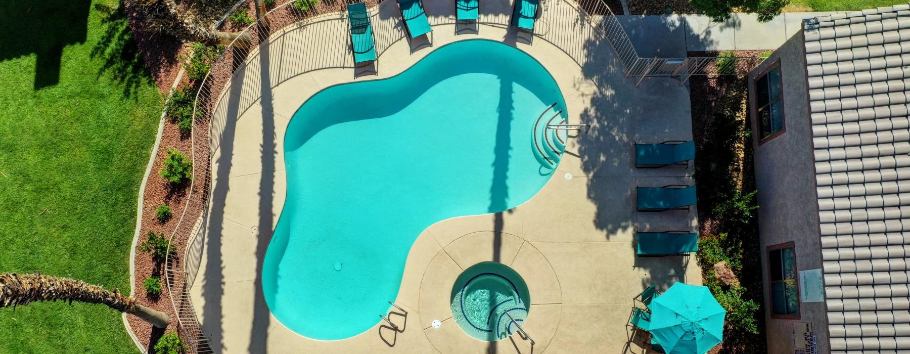 a building with a pool and a large green lawn