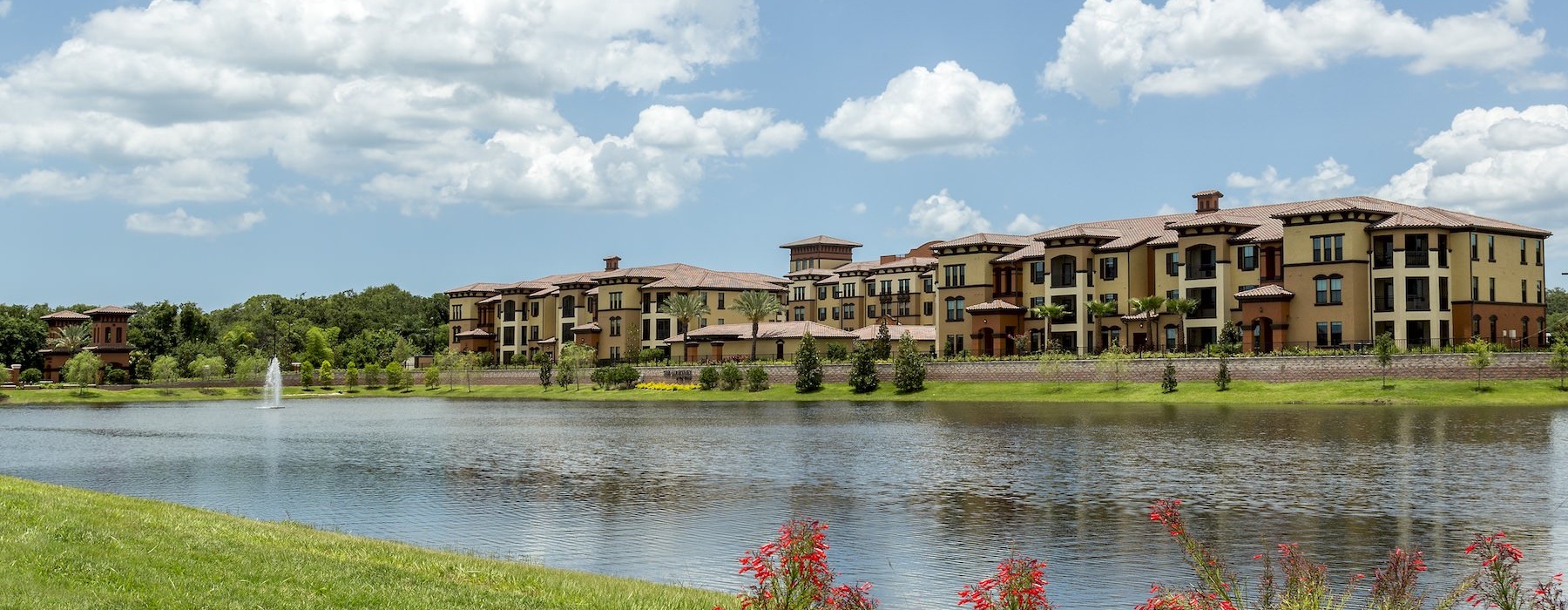 a river with a property next to it and lush landscaping