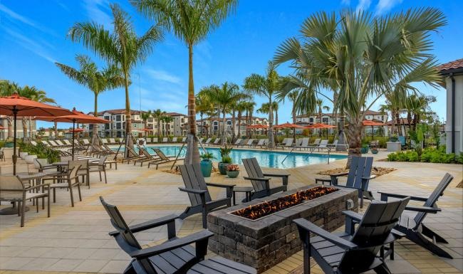 a pool with chairs and tables next to it