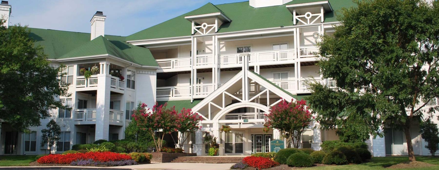a large building with trees and bushes in front of it