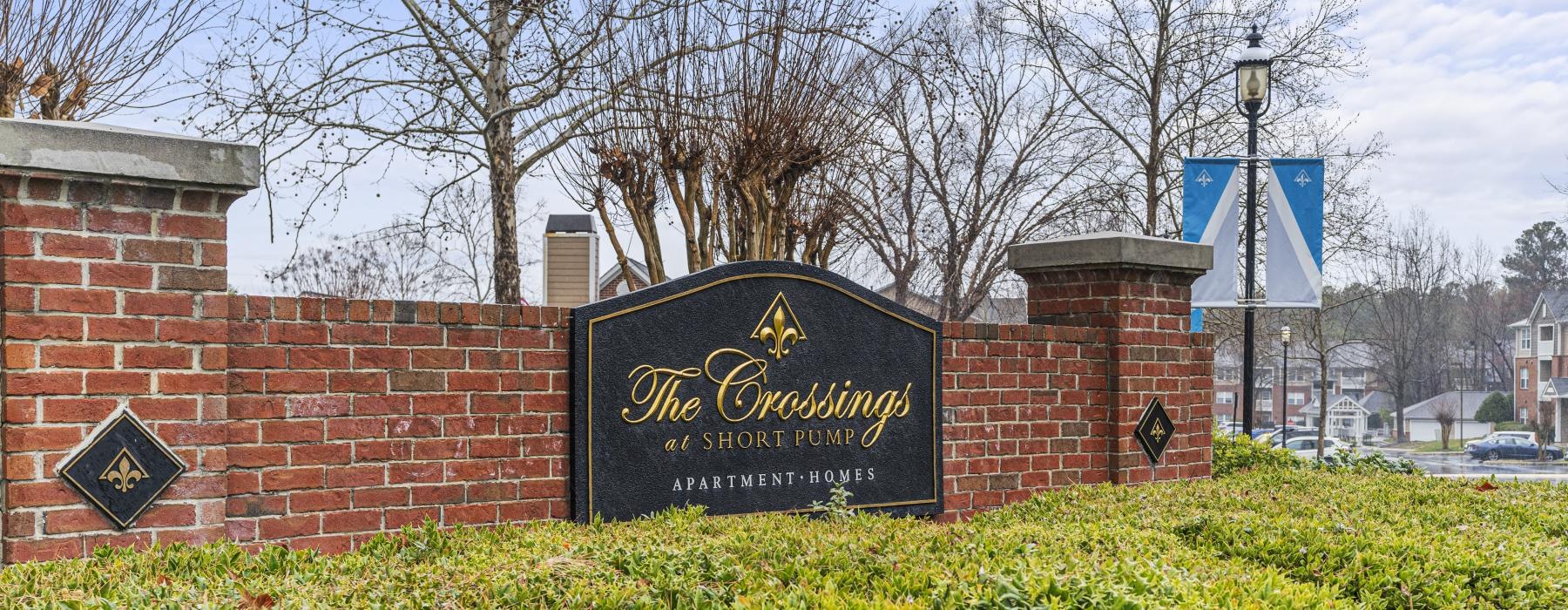 a sign on a brick wall reading the crossings at short pump