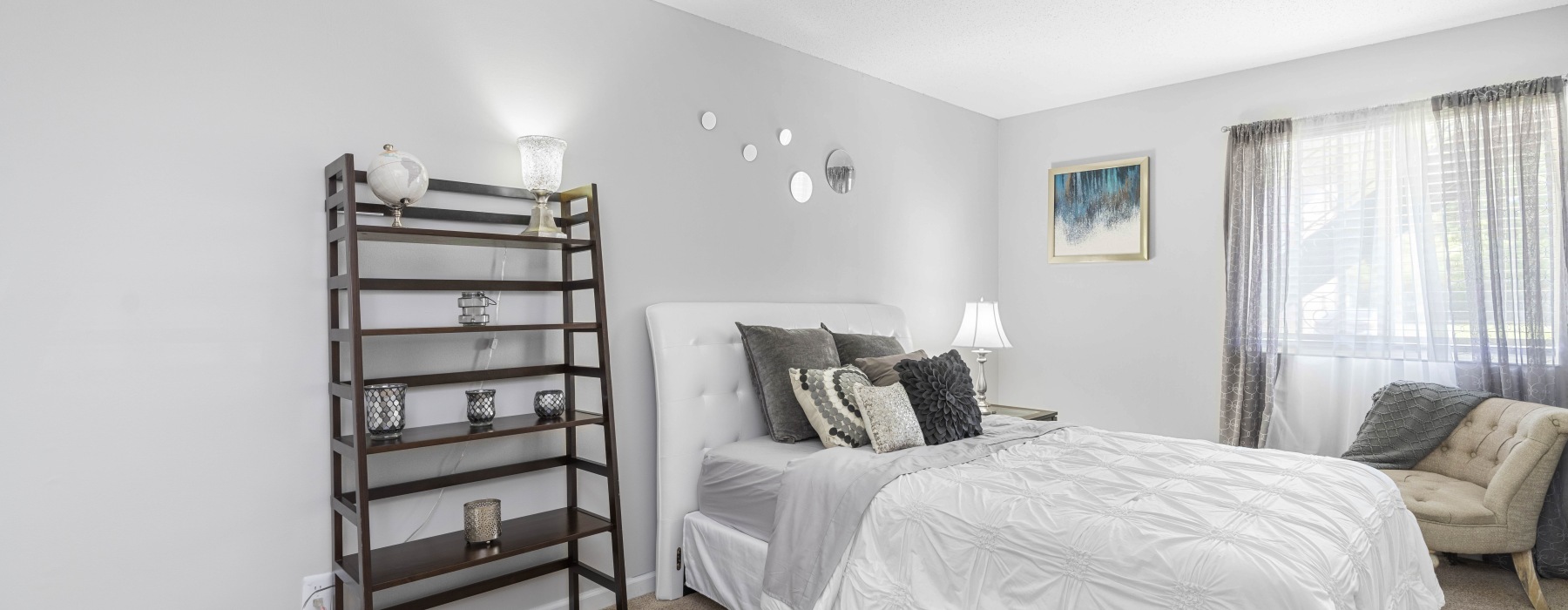 spacious, brightly lit bedroom with accent wall