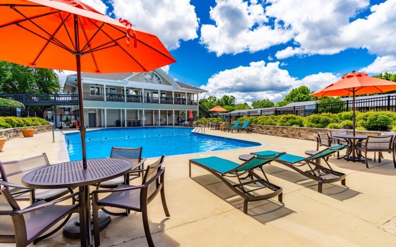 a pool with chairs and umbrellas