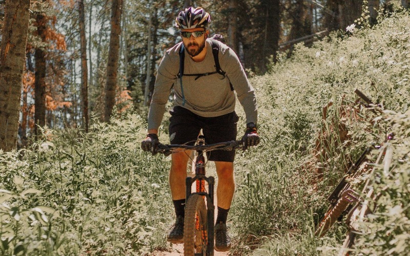 man riding a bike on a trail in the woods