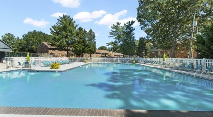 Olympic sized pool with lounge seating and umbrellas 