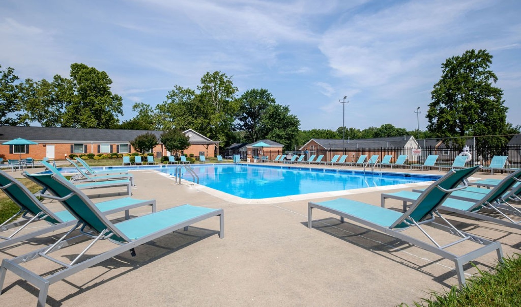 a pool with lounge chairs and umbrellas by it