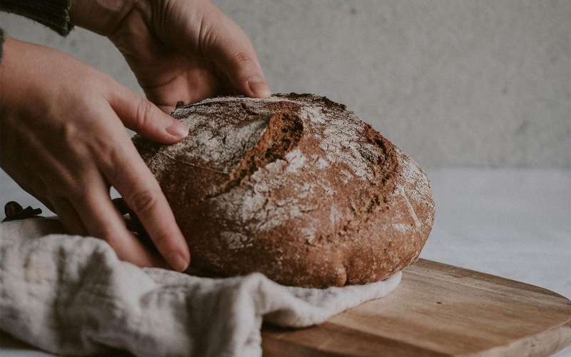 a person holding a loaf of bread