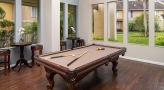 Billiards table is surrounded by windows and café seating
